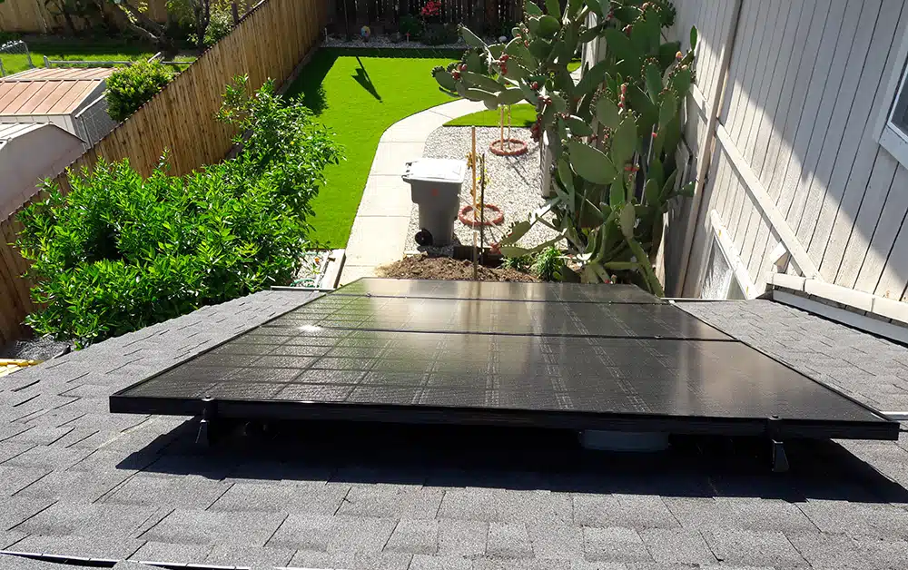 Solar panels on residential roof facing backyard in Sacramento, CA.